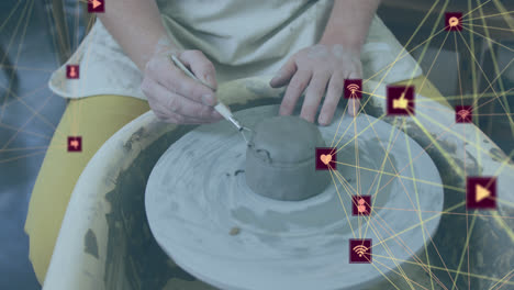 Animation-of-network-of-connections-with-icons-over-caucasian-woman-doing-pottery
