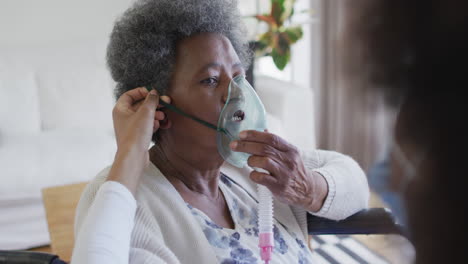 Afroamerikanische-Ärztin-Gibt-Einer-älteren-Patientin-Im-Rollstuhl-Sauerstoff,-Zeitlupe