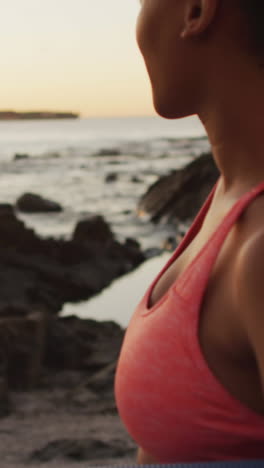 Una-Joven-Birracial-Disfruta-De-Una-Serena-Puesta-De-Sol-En-La-Playa,-Con-Espacio-Para-Copiar