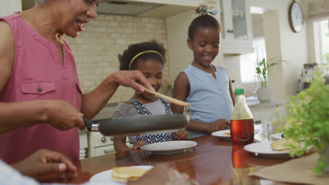 Glückliche-Afroamerikanische-Großeltern-Mit-Enkelinnen-Beim-Frühstück-Und-Reden