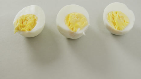 Video-Einer-Nahaufnahme-Von-Drei-Hälften-Hartgekochter-Eier-Auf-Grauem-Hintergrund
