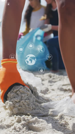 Animation-of-globe-icons-over-hand-of-biracial-female-volunteer-picking-up-rubbish-on-beach