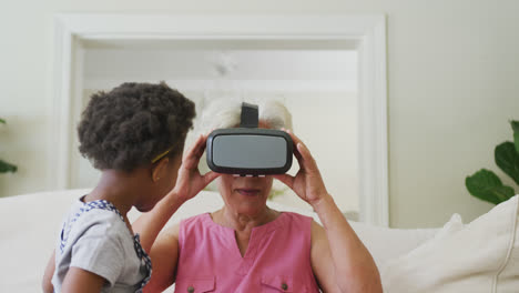 Glückliche-Afroamerikanische-Großmutter-Mit-VR-Headset-Mit-Enkelin-Im-Wohnzimmer