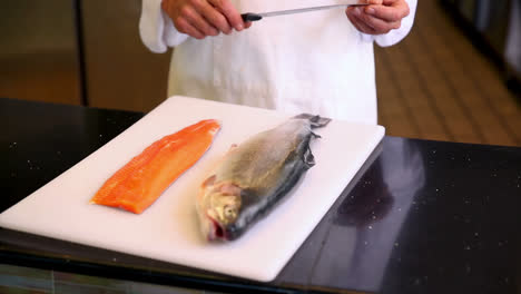 Chef-showing-board-of-whole-salmon-and-fillet