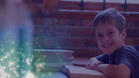 Animation-of-glowing-spots-over-smiling-caucasian-boy-reading-book