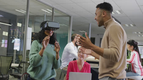 Happy-diverse-male-and-female-business-colleagues-using-vr-headset-in-office