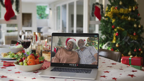 Felices-Abuelos-Afroamericanos-En-Una-Computadora-Portátil-Tumbados-En-La-Mesa-De-Navidad