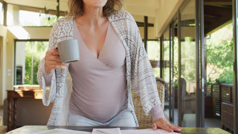 Happy-caucasian-pregnant-woman-with-cup-of-tea-making-video-call
