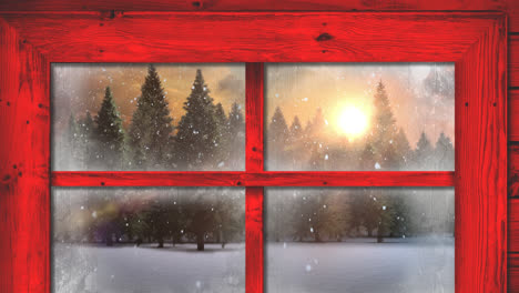 Red-wooden-window-frame-against-snow-falling-over-multiple-trees-on-winter-landscape