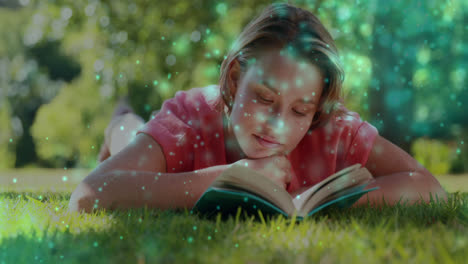 Animation-of-glowing-spots-over-smiling-caucasian-woman-reading-book