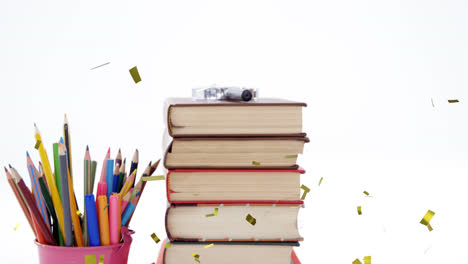 Animation-of-confetti-falling-over-colour-pencils-and-stack-of-books