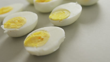 Video-of-close-up-of-halves-of-hard-boiled-eggs-on-grey-background