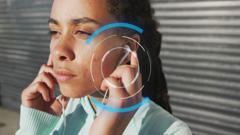 Animation-of-scope-scanning-over-biracial-woman-wearing-earphones