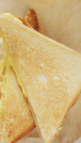 Video-Eines-Frisch-Zubereiteten-Käse-Weißbrot-Sandwiches-Auf-Papier-Und-Weißem-Teller
