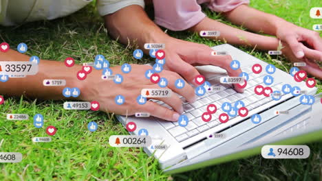 Animation-of-social-media-icons-over-mid-section-of-mother-and-daughter-using-laptop-in-the-garden