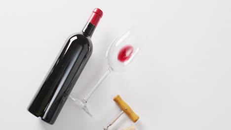 A-bottle-of-red-wine-lies-next-to-a-tipped-glass,-with-copy-space