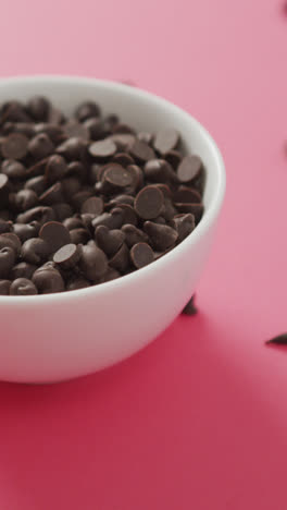 Video-of-bowl-of-chocolate-chip-over-pink-background