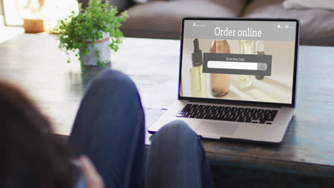 Woman-at-table-using-laptop,-online-shopping-for-beauty-products,-slow-motion