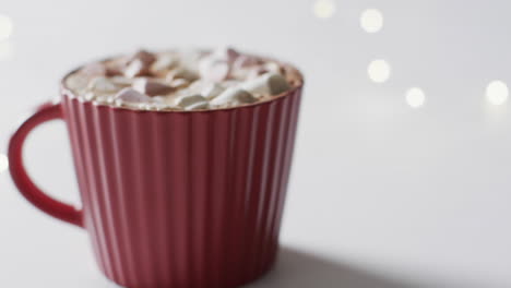 Video-of-red-mug-of-christmas-chocolate-with-marshmallows-and-copy-space-on-white-background