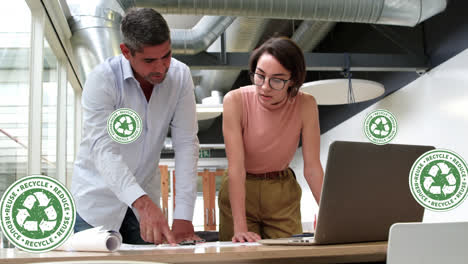 Animation-of-recycle-symbols-and-plastic-bottle-over-diverse-man-and-woman-discussing-at-office