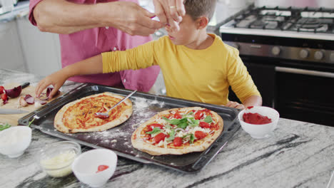 Glücklicher-Kaukasischer-Großvater-Und-Enkel-Machen-Pizza-In-Der-Küche,-Zeitlupe
