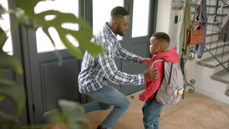 Happy-african-american-father-saying-goodbye-to-son-before-he-leaves-house-for-school,-sow-montion
