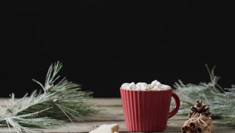 Video-of-red-mug-of-christmas-chocolate-with-marshmallows-and-copy-space-on-wooden-background