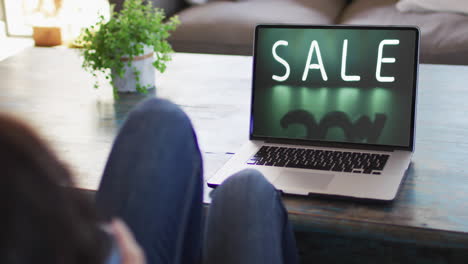 Knie-Einer-Frau-Am-Tisch-Mit-Laptop,-Online-Shopping-Während-Des-Verkaufs,-Zeitlupe