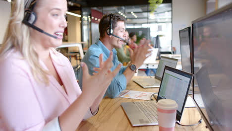 Happy-caucasian-casual-businesswoman-and-diverse-colleagues-using-phone-headsets,-slow-motion