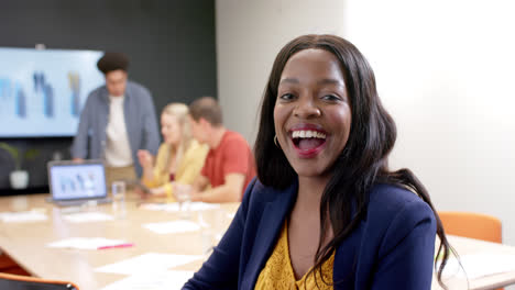 Portrait-of-happy-african-american-casual-businesswoman-with-colleagues-in-meeting-room,-slow-motion