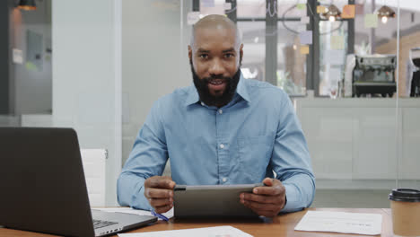 Portrait-of-african-american-businessman-using-tablet,-making-video-call-in-office,-slow-motion