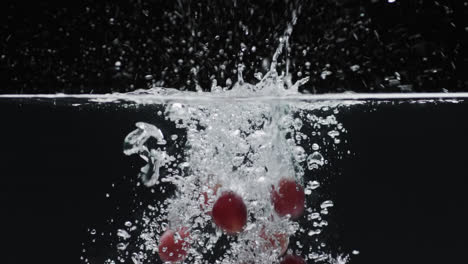 Video-of-grapes-falling-into-water-with-copy-space-on-black-background