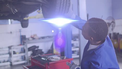 Lichtanimation-über-Einem-Afroamerikanischen-Mechaniker,-Der-Ein-Auto-Repariert