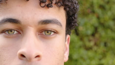 Biracial-man-face-close-up-and-looking-into-camera-outdoors,-slow-motion