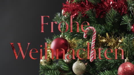 Frohe-Weihnachten-Texto-En-Rojo-Sobre-Un-árbol-De-Navidad-Decorado-Sobre-Fondo-Negro
