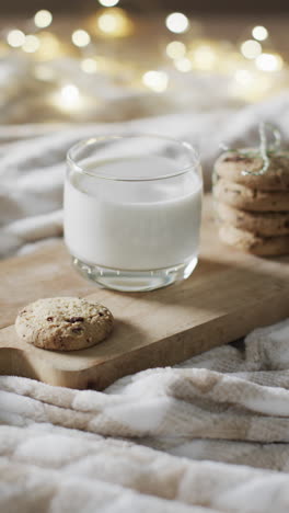 Vertical-video-of-mug-of-milk-and-christmas-cookies-and-copy-space-on-white-background