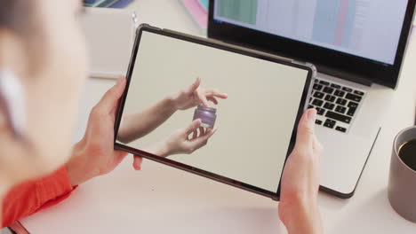 Caucasian-woman-at-desk-using-tablet,-online-shopping-for-beauty-products,-slow-motion