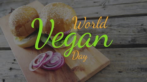 Animation-of-world-vegan-day-text-in-orange-and-green-over-vegetarian-burgers-and-red-onion