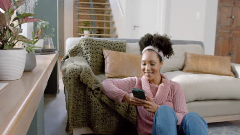 Mujer-Birracial-Feliz-Usando-Un-Teléfono-Inteligente-En-Casa,-Cámara-Lenta