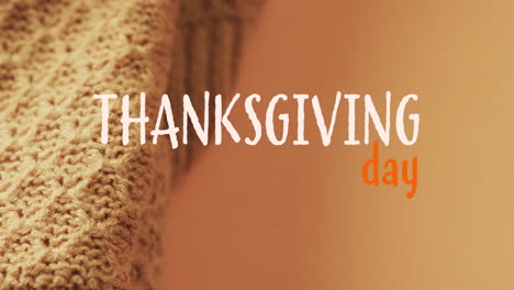 Animation-of-thanksgiving-day-text-and-wooly-blanket-on-brown-background