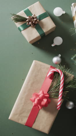Vertical-video-of-christmas-presents-and-copy-space-on-green-background