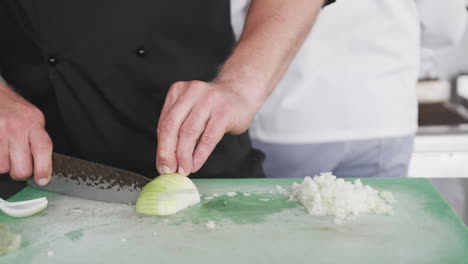 Caucasian-male-chef-cutting-vegetables-in-kitchen,-slow-motion