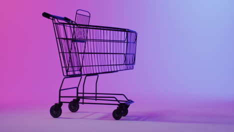 Ein-Einkaufswagen-Ist-Vor-Einem-Violett-rosa-Hintergrund-Mit-Farbverlauf-Zu-Sehen,-Mit-Platz-Zum-Kopieren