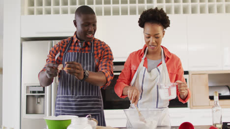 Video-of-happy-african-american-couple-baking-together-in-kitchen