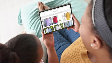 African-american-mother-and-daughter-using-tablet,-online-shopping-for-clothes,-slow-motion