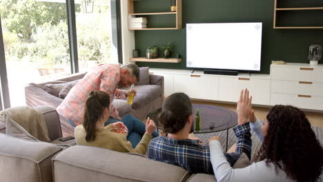 Excited-diverse-male-and-female-friends-watching-sport-on-tv-at-home,-copy-space-on-screen