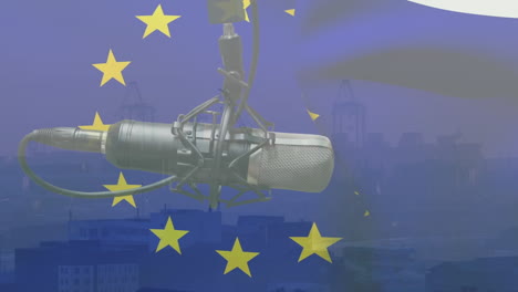 Animation-of-waving-eu-flag-over-microphone-against-aerial-view-of-cityscape
