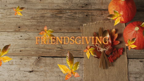 Animation-of-friendsgiving-text-over-cutlery-and-autumn-leaves-over-wooden-surface