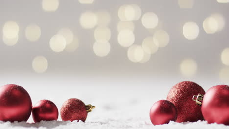 Video-of-red-christmas-baubles-decorations-with-copy-space-on-snow-background
