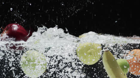 Video-of-fruit-falling-into-water-with-copy-space-on-black-background